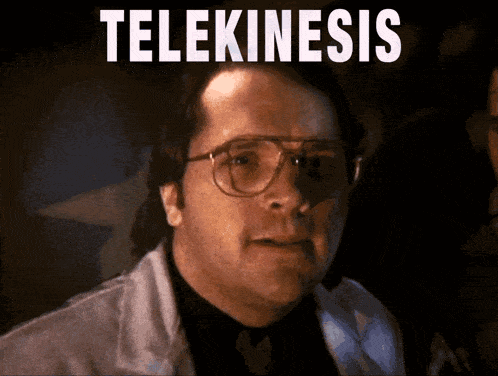 a man wearing glasses and a lab coat has the word telekinesis written on his face