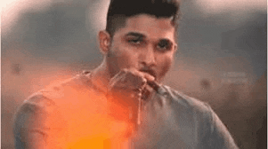 a man is smoking a cigarette while holding a pair of keys in his hand .