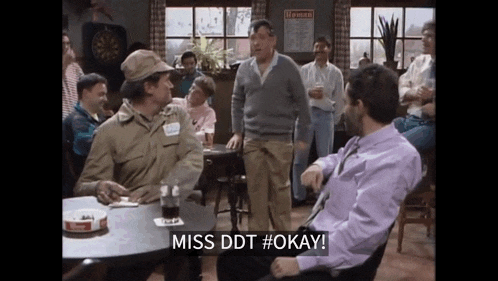 a group of men are sitting around a table and one man says miss ddt #okay