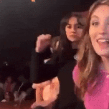 two women are dancing together in a dark room .