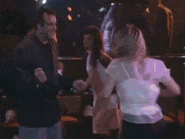 a woman in a white dress is dancing in a crowd