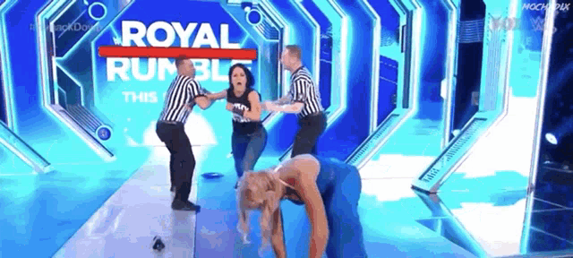 a woman is laying on the floor in front of a royal rumble sign
