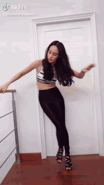 a woman is dancing in front of a door with a tiktok watermark