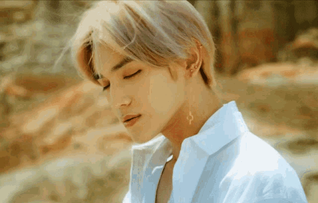 a man wearing a white shirt has a key earring on his neck