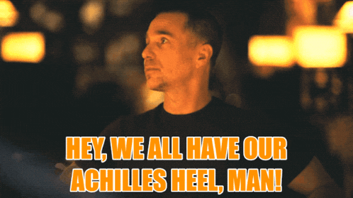 a man in a black shirt with the words hey we all have our achilles heel man above him