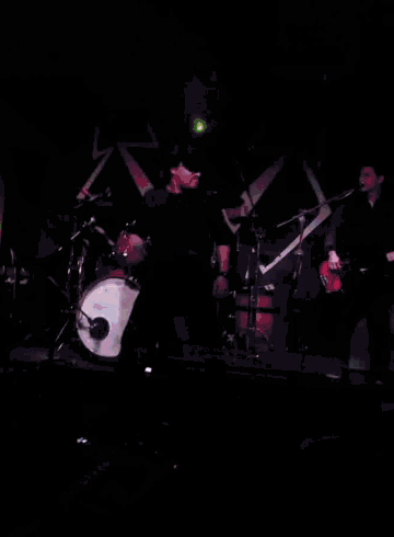 a man in a hat is dancing on a stage in front of a sign that says z