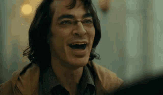 a close up of a man laughing with his mouth wide open .