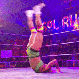 a wrestler is doing a handstand in front of a sign that says sol