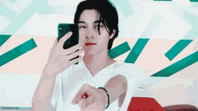 a young man is taking a selfie with a cell phone .