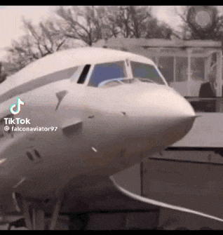 a man in a suit is standing in front of a large white airplane .