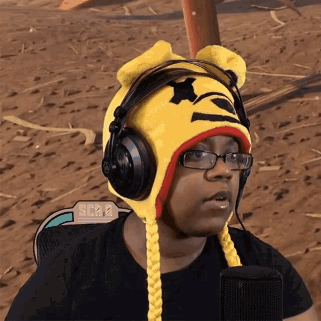 a woman wearing headphones and a hat with a winnie the pooh face