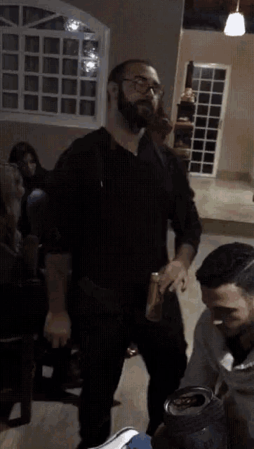 a man in a black shirt is holding a can that says ' coca cola ' on it