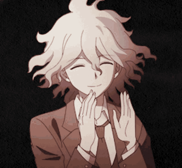 a man in a suit is smiling with his hands folded in front of his face