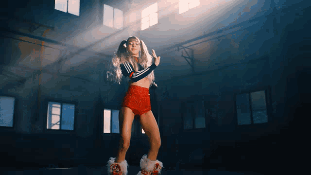 a woman in a crop top and shorts is dancing