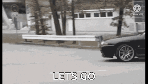 a black and white photo of a car driving down a street with the words `` lets go '' written on it .