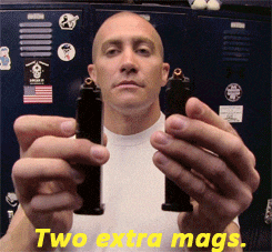 a man is holding two magazines in front of a locker with stickers on it
