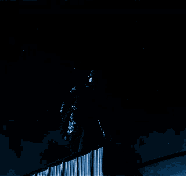 a person standing on a railing with lightning strikes behind them