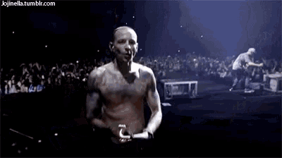 a man without a shirt is standing on a stage .