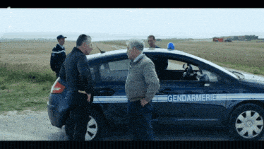 a gendarmerie car is parked on the side of a road