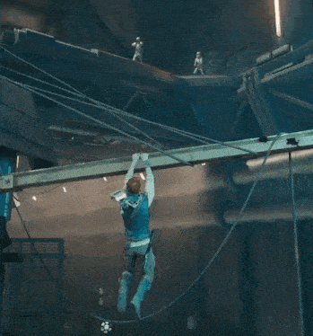 a man is hanging from a rope with a red light coming from it