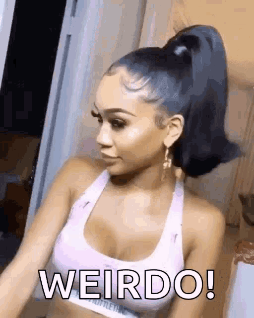 a woman with a ponytail is wearing a pink sports bra and earrings and says weirdo .