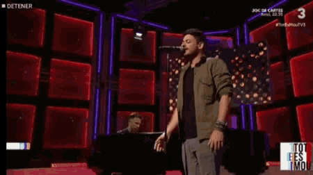 a close up of a person singing into a microphone with the number 3 in the background