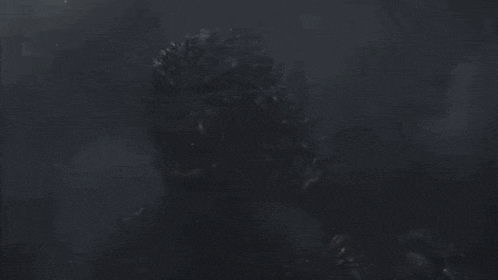 a monster is standing in the dark with its mouth open and looking at the camera .