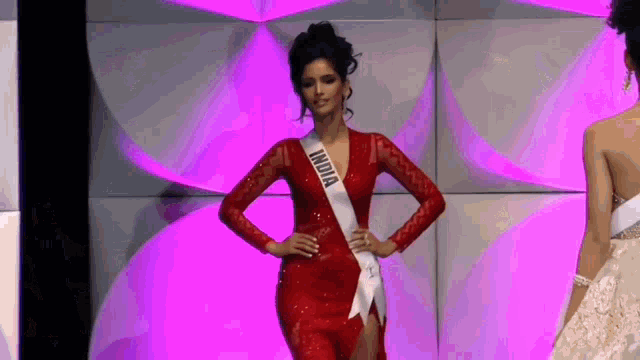 a woman wearing a red dress and a sash that says india