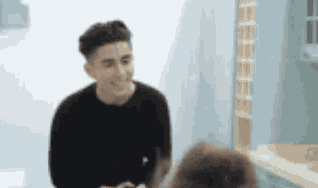 a man in a black sweater is standing next to a woman in a bathroom .