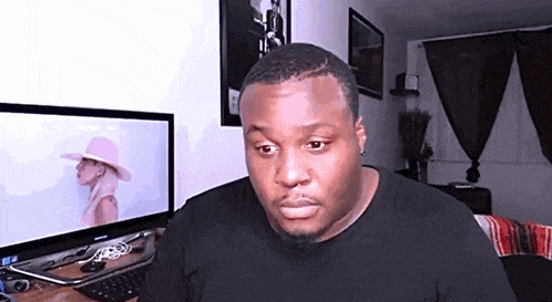a man is sitting in front of a computer monitor .
