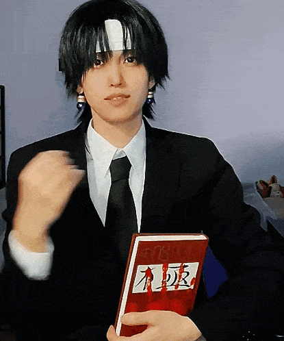 a man in a suit and tie is holding a red book that says a.d.r. on it
