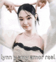 a woman is making a heart shape with her hands and the words `` lynn y amy amor real '' .