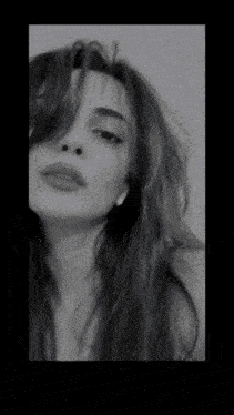 a black and white photo of a woman 's face with long hair