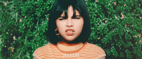 a young girl with short hair is making a funny face .