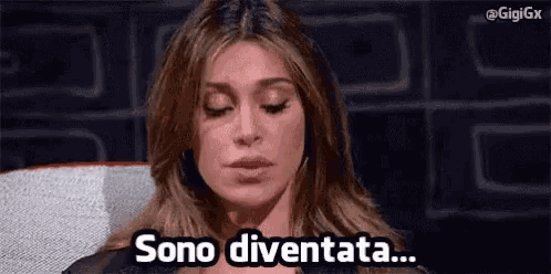 a woman is sitting in a chair with her eyes closed and the words sono diventata written on her face .