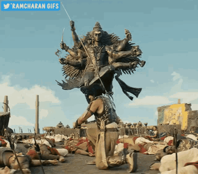 a ramcharan gif shows a man kneeling in front of a large statue