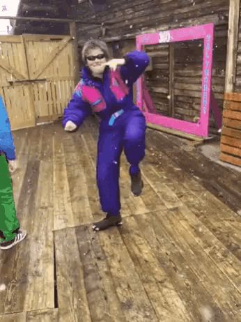 a woman in a blue and pink ski suit is dancing