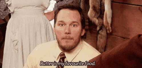 a man in a yellow shirt and tie is sitting in front of a woman and saying butter is my favourite food .