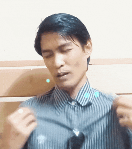 a man in a striped shirt is holding something in his hands