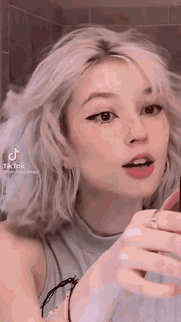 a girl is taking a selfie in front of a mirror .