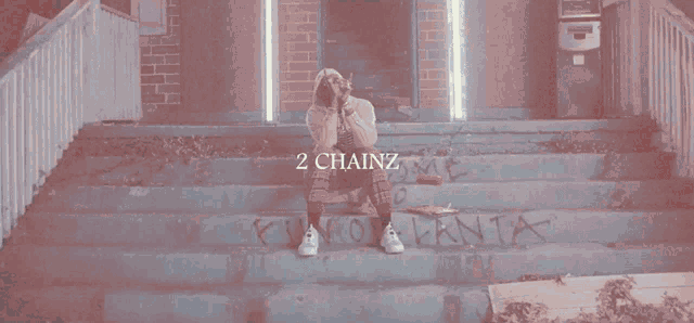a man sits on a set of stairs with the words 2 chainz on the bottom