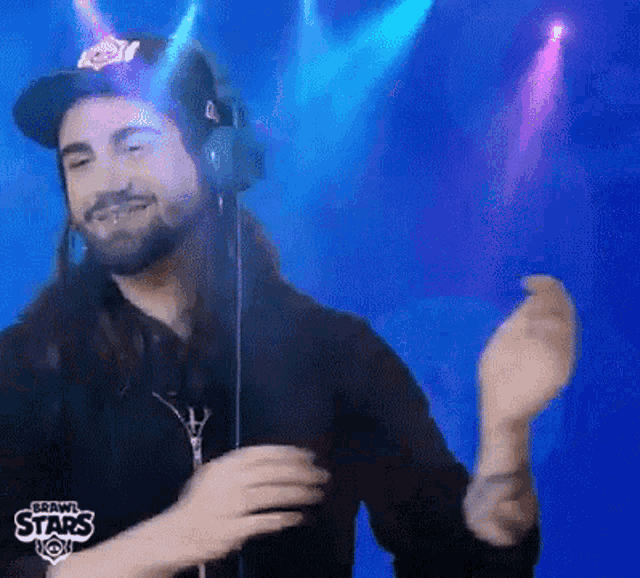 a man with long hair and a beard wearing headphones and a hat that says crown stars