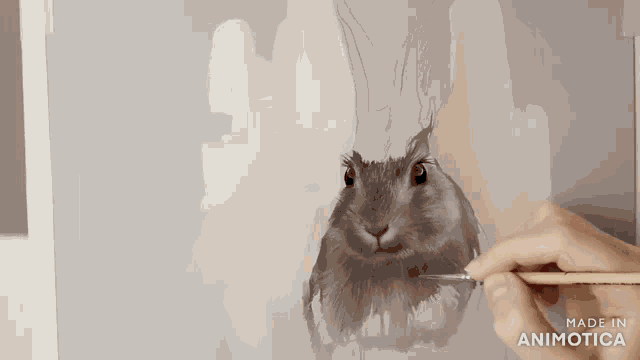 a person is painting a rabbit with a brush and the words made in animotica are on the bottom