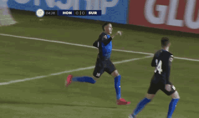 a soccer player with the number 14 on his back kicks the ball