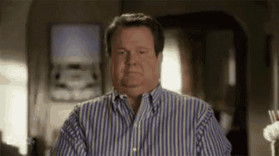 a man in a striped shirt is making a funny face in a room .