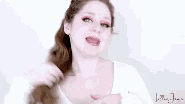 a woman in a white shirt is making a funny face .