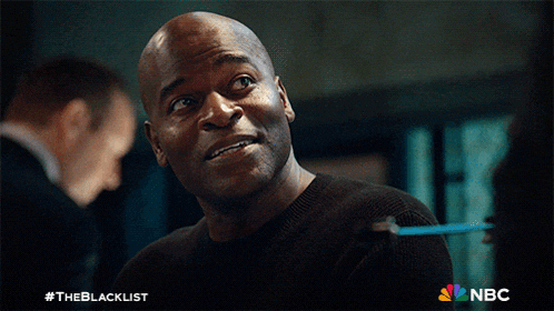 a man in a black sweater with the nbc logo on the bottom