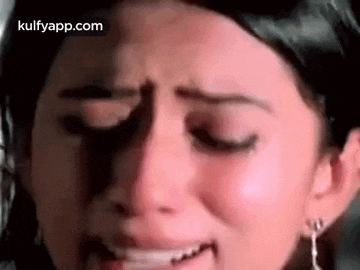 a close up of a woman 's face with her eyes closed and tears running down her face .