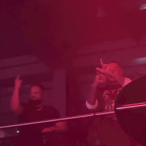 a man giving the middle finger while another man looks on