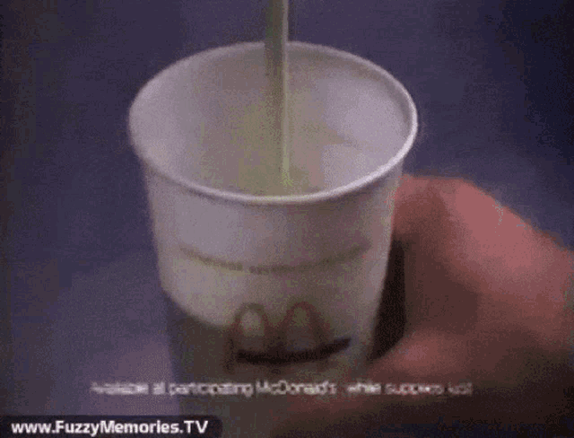 a person pouring milk into a mcdonalds cup
